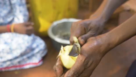 Close-up-of-an-African-woman's-hand-peeling-potatoes-with-a-knife