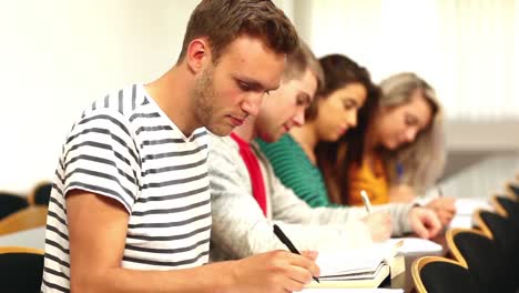estudiantes enfocados tomando notas en clase