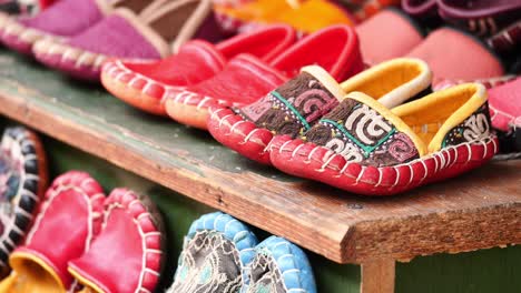 colorful handmade children's slippers on a wooden shelf