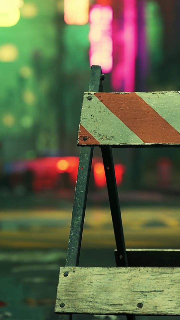 Una barriera stradale è posizionata sulla strada di notte con le luci della città sullo sfondo.
