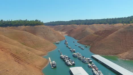 Erstaunliche-Luftaufnahme-über-Dem-Von-Der-Dürre-Betroffenen-Kalifornischen-Oroville-See-Mit-Niedrigem-Wasserstand,-Zurückweichender-Küstenlinie-Und-Gestrandeten-Hausbooten