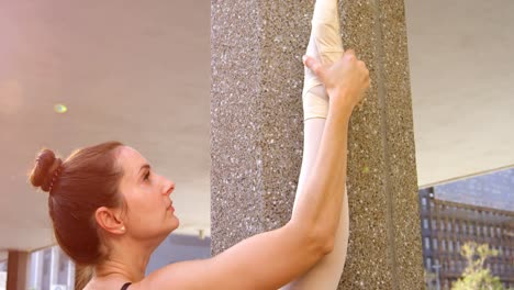 ballet dancer stretching on pillar 4k