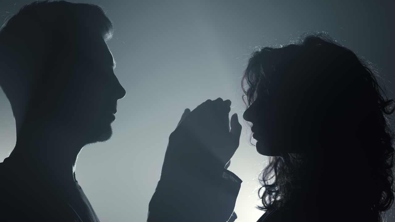 실루 ⁇  커플이 실내에서 서로 만지고 있다. 손을  ⁇ 고 있는 남자와 여자.