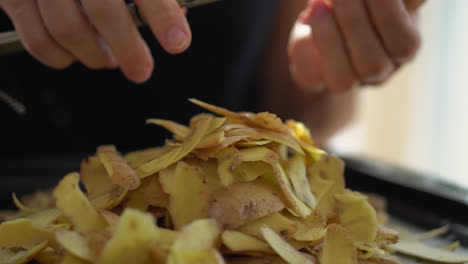 mujer zurda usando un pelador para quitar la piel de las papas