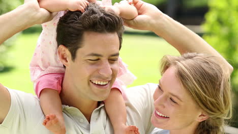 happy parents with their baby girl in the park