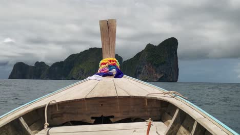 bow of a wooden longtail boat with flowers in the tropical seas of the andaman in thailand