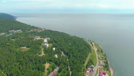aerial view of lakeside town with forest and mountains