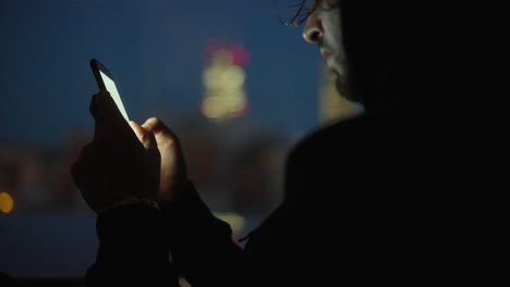 man using phone at night