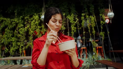 woman eating asian food outdoors