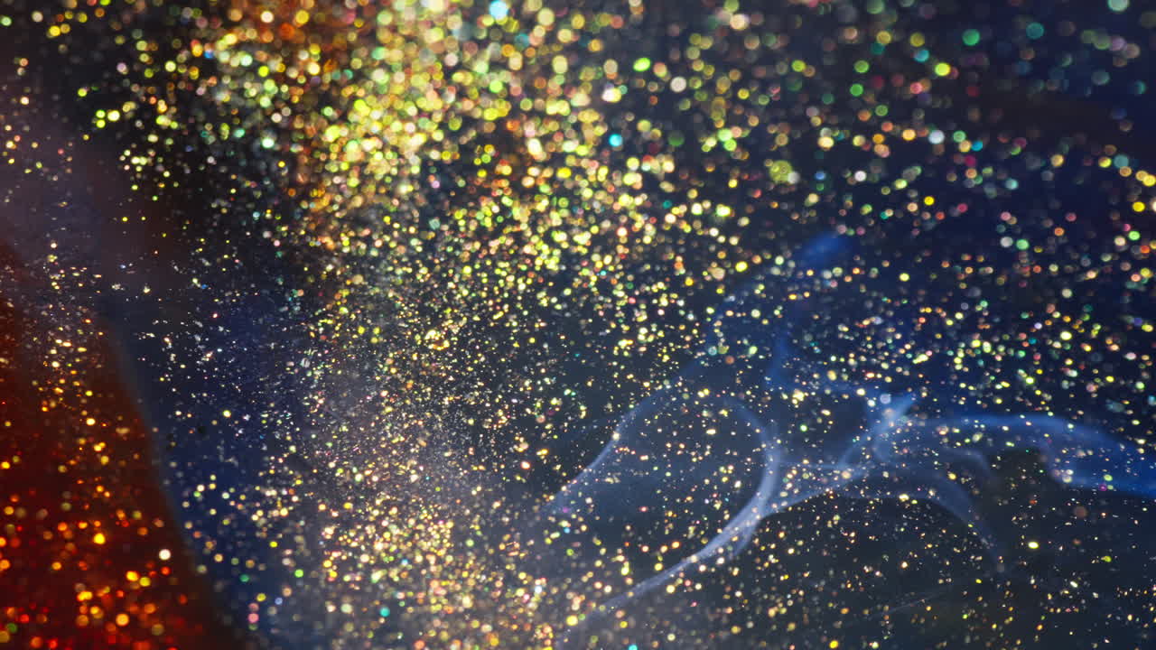 Sfondo astratto di arte fluida con inchiostri colorati e glitter scintillanti.