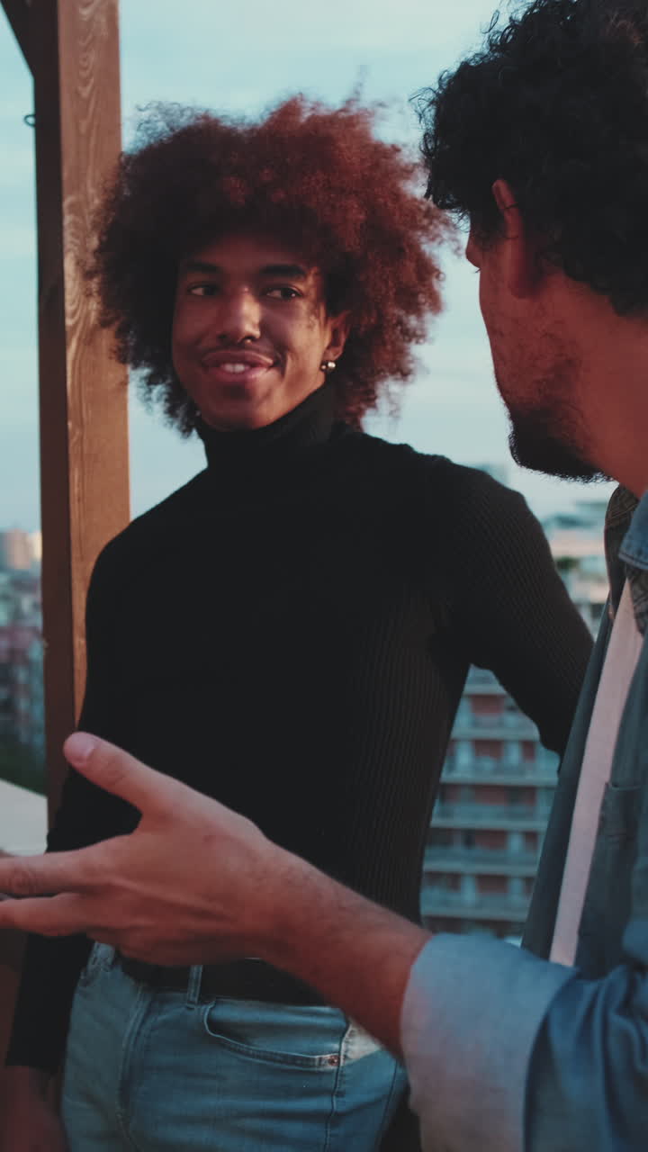 Two friends chatting on a balcony with city view