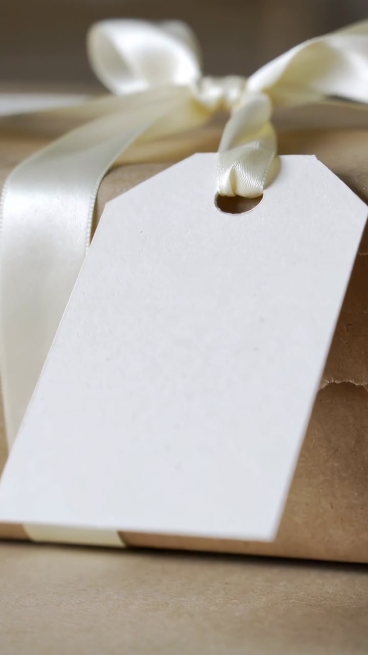 Gift Wrapped in Brown Paper with White Ribbon and Blank Tag