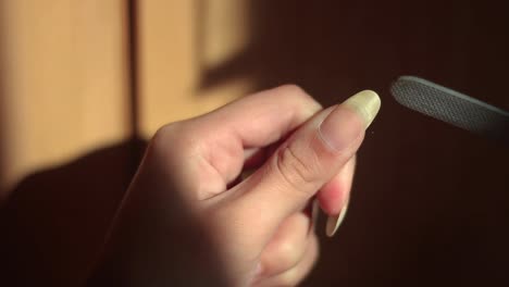 long natural strong nail filed by a woman on the golden hour