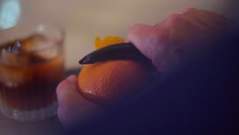 preparando un cóctel de martini, ron, naranja y hielo