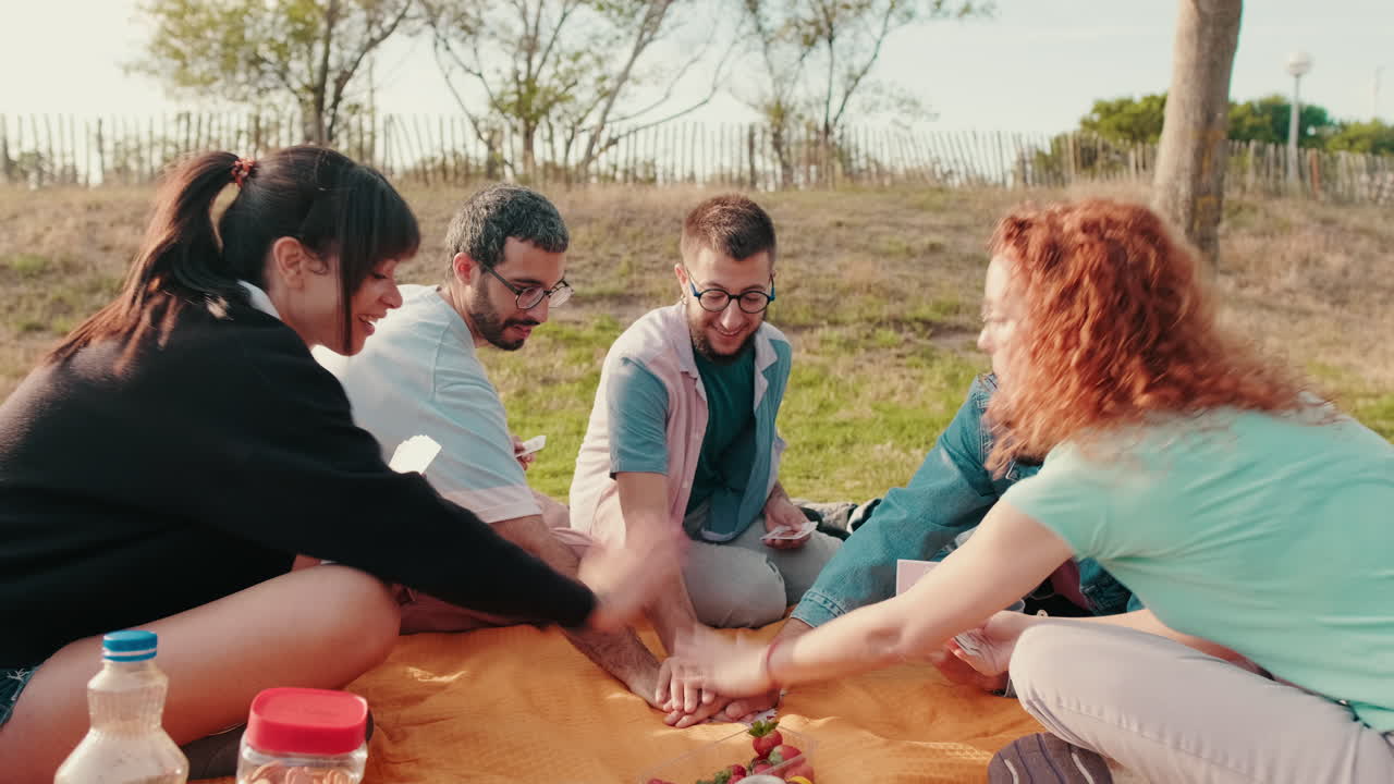 Friends Enjoying a Picnic and Card Game
