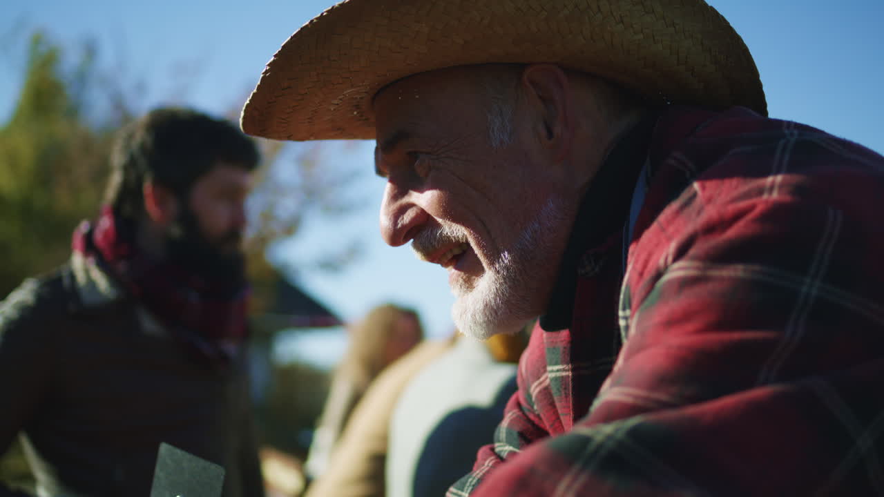 Senior Happy Farmer Selling Fruits and Vegetables Senior Happy Farmer Selling Fruits and Vegetables at the Stall Talking and Smiling Local Farmers Market or Autumn Fair Outdoors Vegetarian and Organic Food Agriculture Point of Sale system