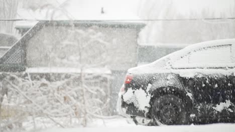 coche cubierto de nieve durante una tormenta de nieve en la ciudad