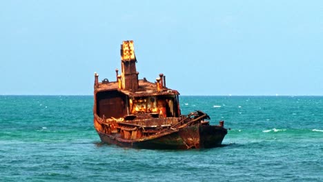 the rusted hull of an old ship off the coast of the island of sao tome and principe