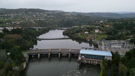 visión aérea en alto ángulo de la central eléctrica y la presa con reflejo del puente en el agua