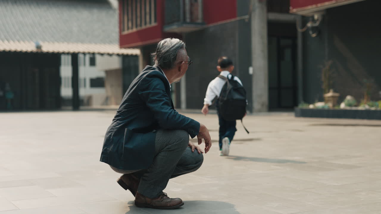 A student high-fives his teacher outside of school