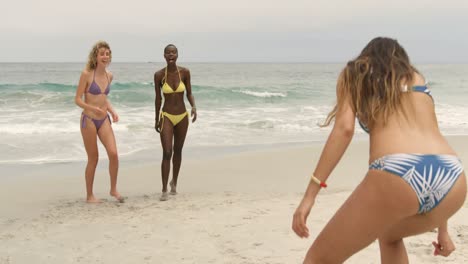 Group-of-mixed-race-female-friends-playing-flying-disc-on-the-beach-4k
