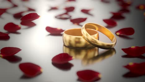 dos anillos de boda dorados sobre una superficie negra brillante mientras caen pétalos de rosas rojas