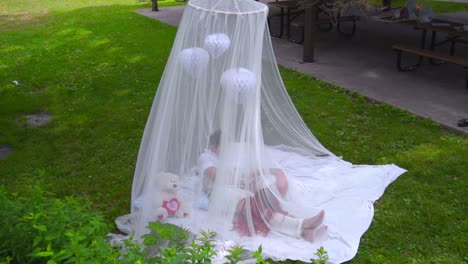 tender couple resting behind white veil on green grass. love couple relax