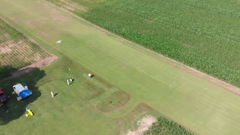 remote control airplane taking off in corn field shot with drone