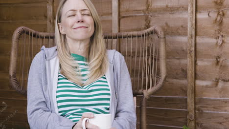 woman relaxing with coffee in garden chair