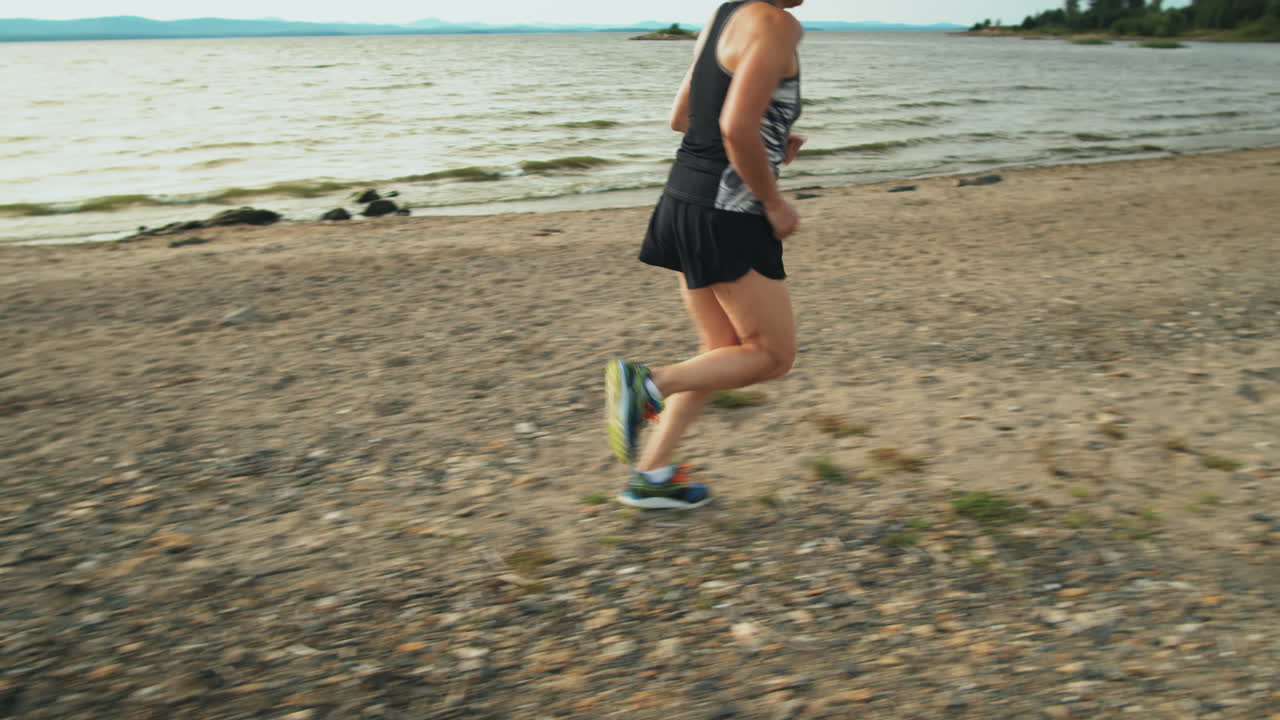 mujer corriendo a lo largo de la orilla del lago