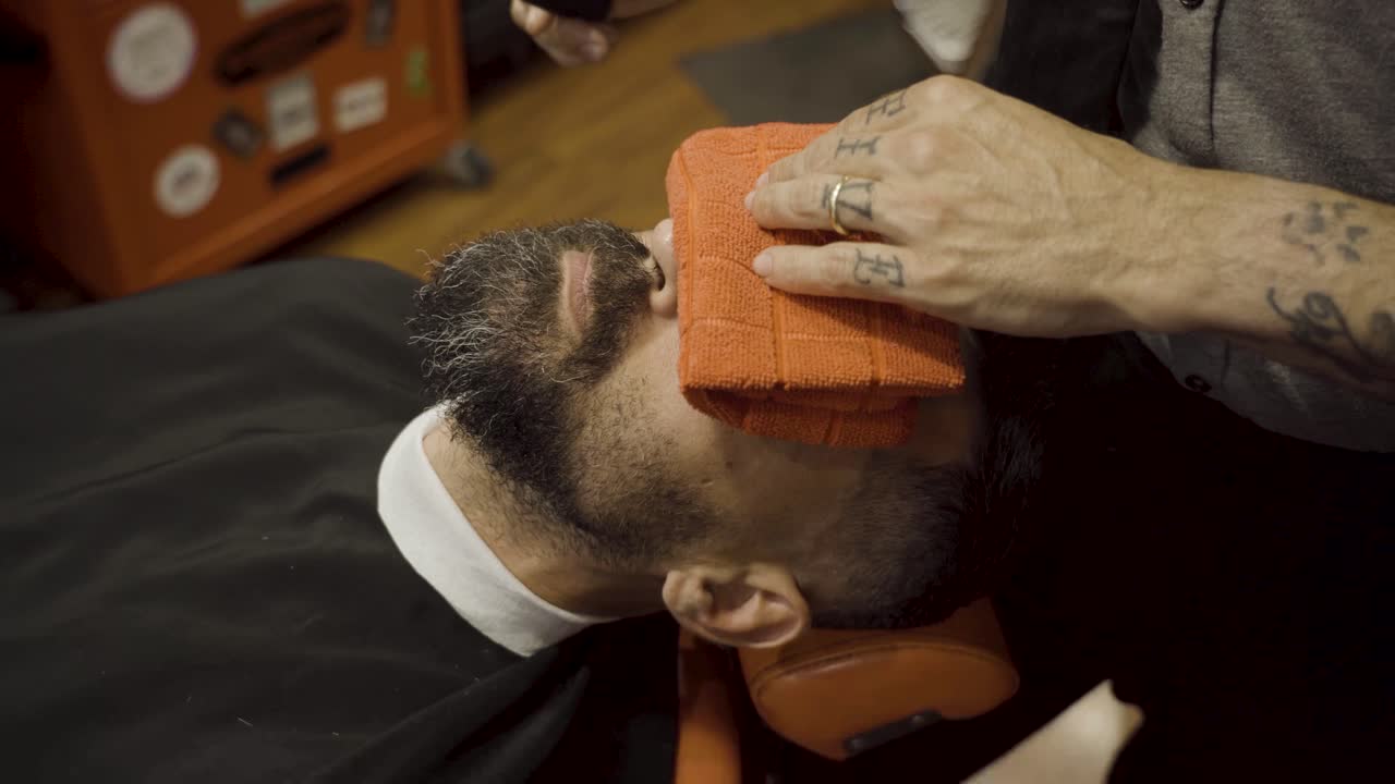 barbero peinando la barba del hombre en la barbería - de cerca