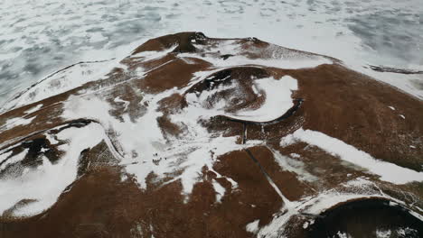 flying over skútustaðagígar craters of iceland, snowy volcanic lands, geology site and wetlands of lake myvatn area, famous natural phenomenon, touristic attraction, aerial view