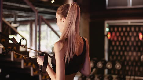 Slow-Motion-Of-Young-Sporty-Woman-Exercising-On-Machine-At-Health-Studio