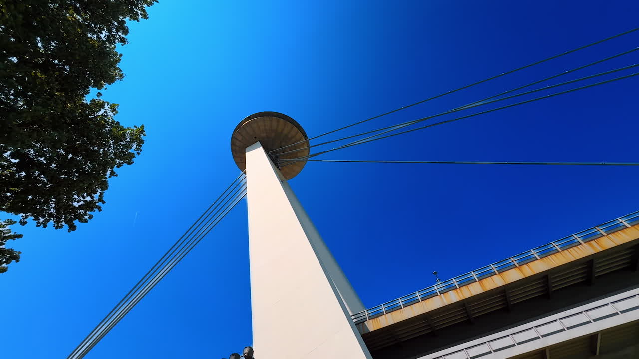Saucer-shaped observation deck and restaurant perched atop the pylon of UFO Bridge in Bratislava, Slovakia. Low angle view at the support of the Bridge of the Slovak National Uprising at the backdrop of blue sky