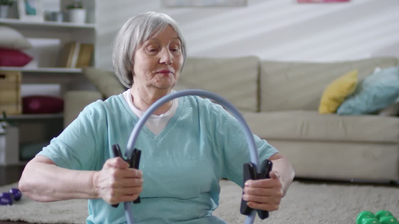 고위 여성은 집에서 저항 반지와 함께 훈련합니다.