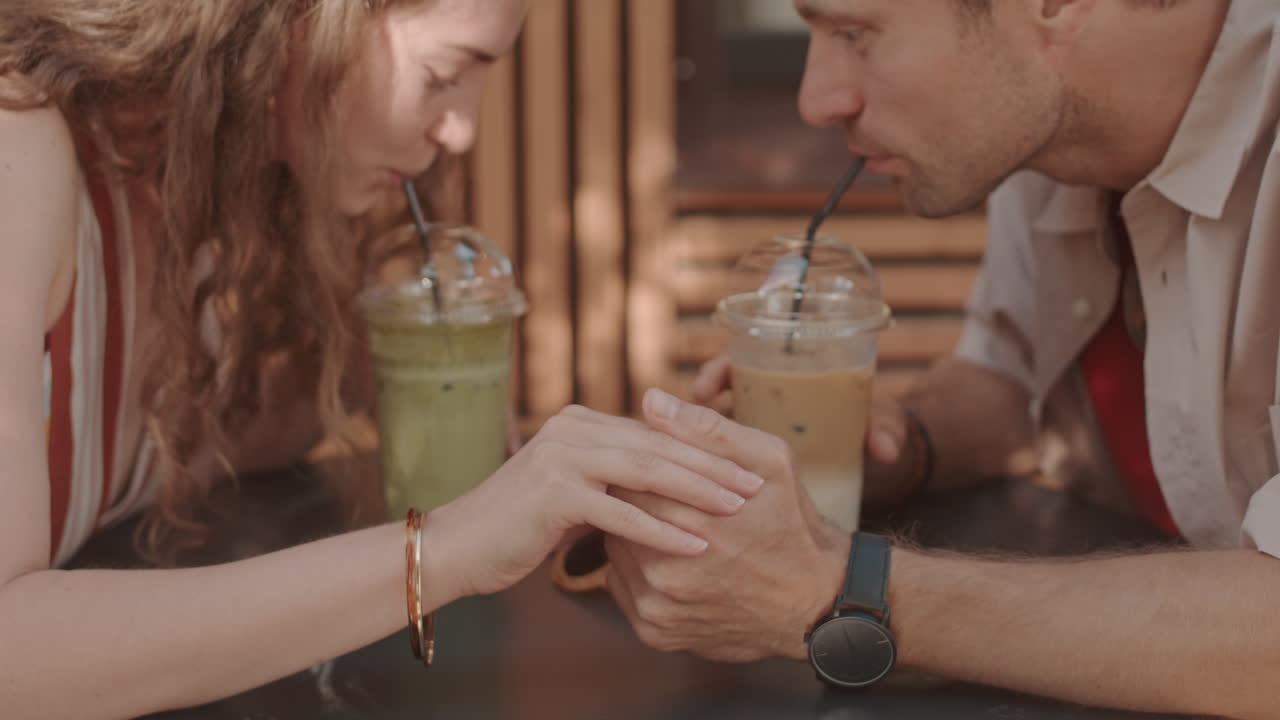 Couple Holding Hands Drinking Iced Beverages
