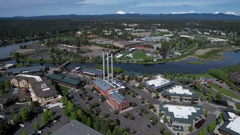 The-Old-Mill-in-Bend,-Oregon-with-Deschutes-River-and-Cascade-Mountains-in-the-distance