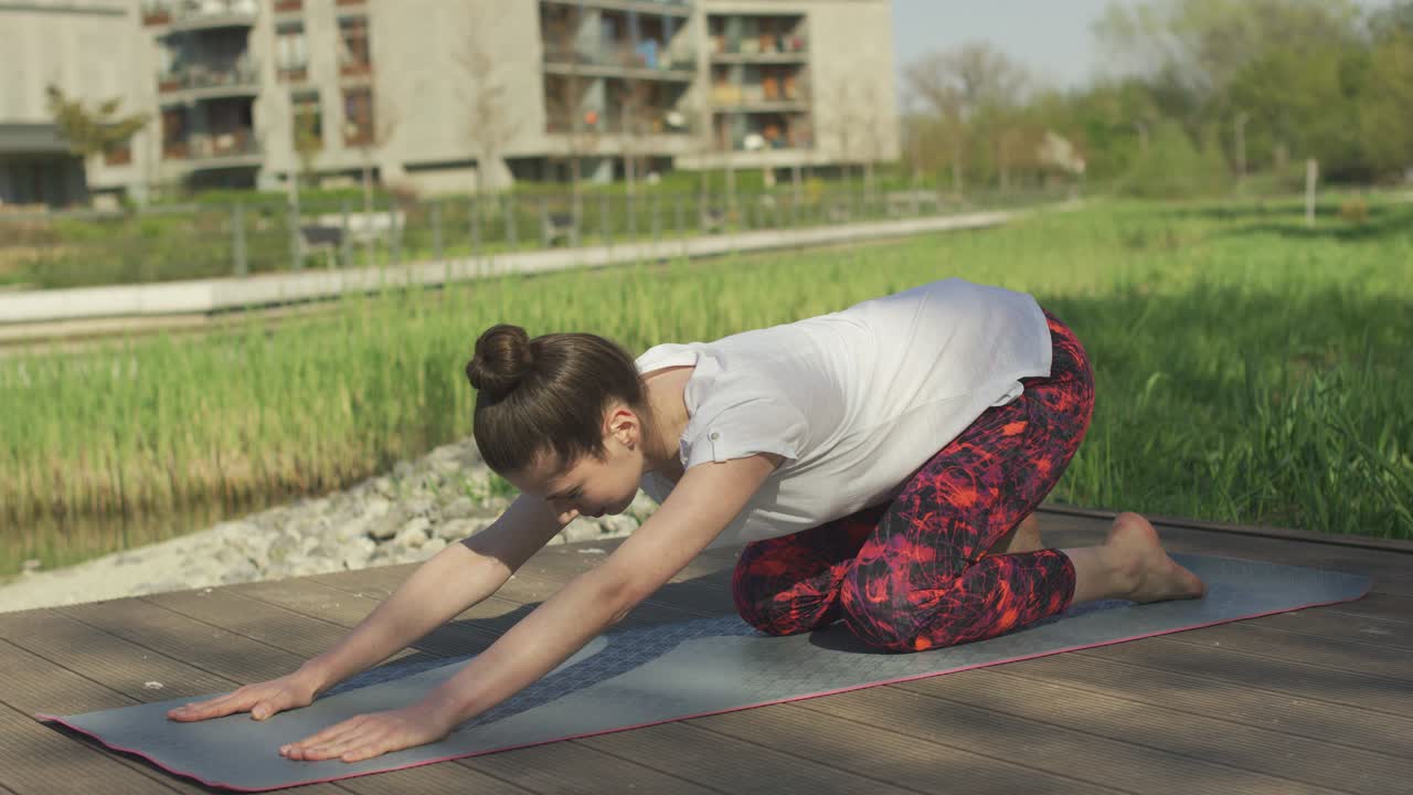 mujer joven realizando pose de yoga al aire libre 4k