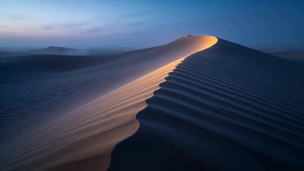 Luce solare calda e cangiante che inonda una grande duna di sabbia in un deserto remoto, rivelando motivi a increspatura.