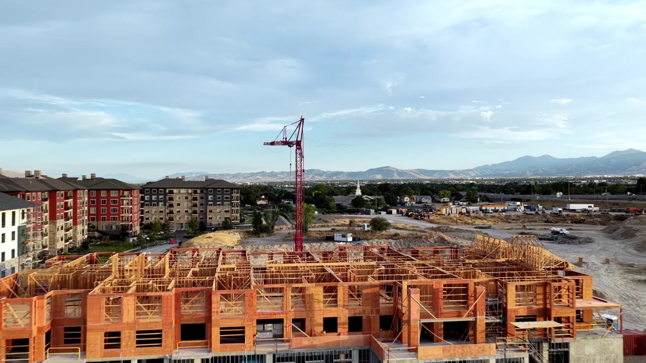 Costruzione di appartamenti con struttura in legno con gru a torre, strutture intelaiate, lavori di sterro attivi e quartieri residenziali circostanti a Taylorsville, Contea di Salt Lake, Utah, Valle di Salt Lake, USA