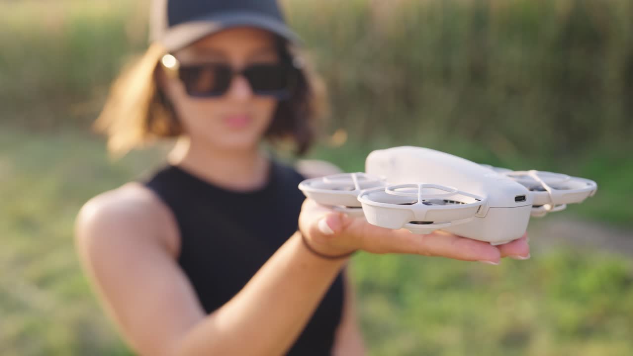 Female hold compact drone model on palm and push button on device, Czechia