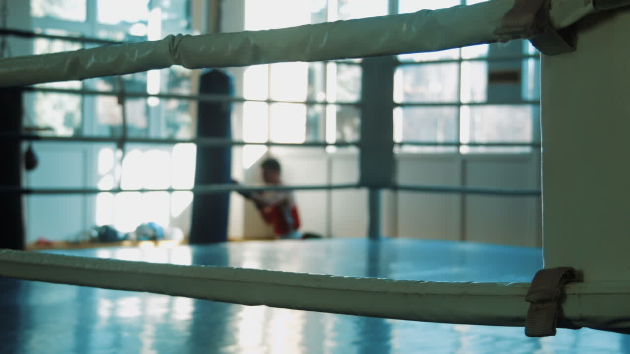 Silhouette Of Young Boxer Training With Punching Bag