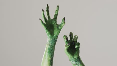 video of halloween green monster hands with copy space on grey background