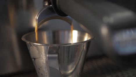 Barista-Schaumiger-Kaffee-In-Zeitlupe,-Der-Eine-Tasse-Aus-Rostfreiem-Stahl-Füllt