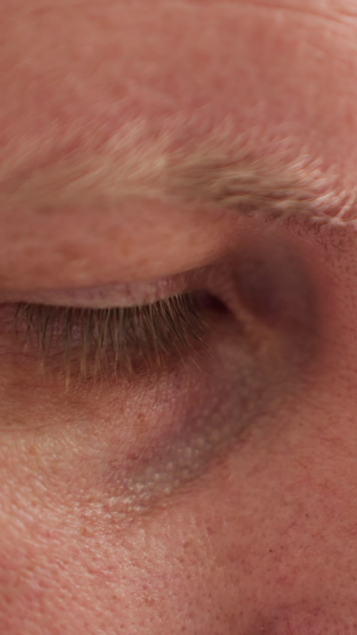 una vista de cerca de la cara de un técnico, destacando la concentración y el enfoque intensos, con un fondo verde borroso