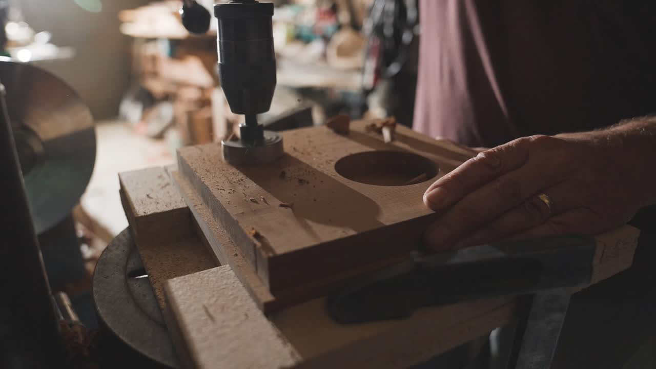 Forstner drilling bit on milling machine cutting hole in wooden board, wood shavings