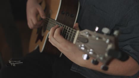 close up of a western acoustic guitars body being played by a professional musician during a recording session. shot in 4k. smooth panning