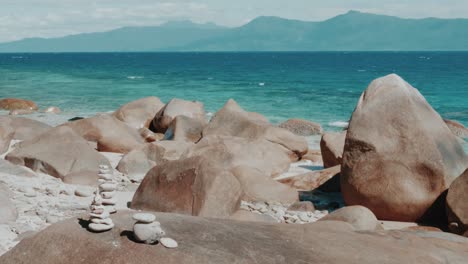 beautiful beach with rocks, stone towers and blue ocean in the background in on fitzroy island in queensland, australia