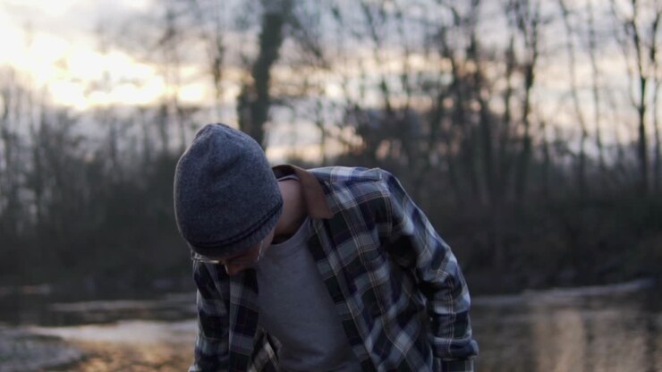 Guy standing next to river