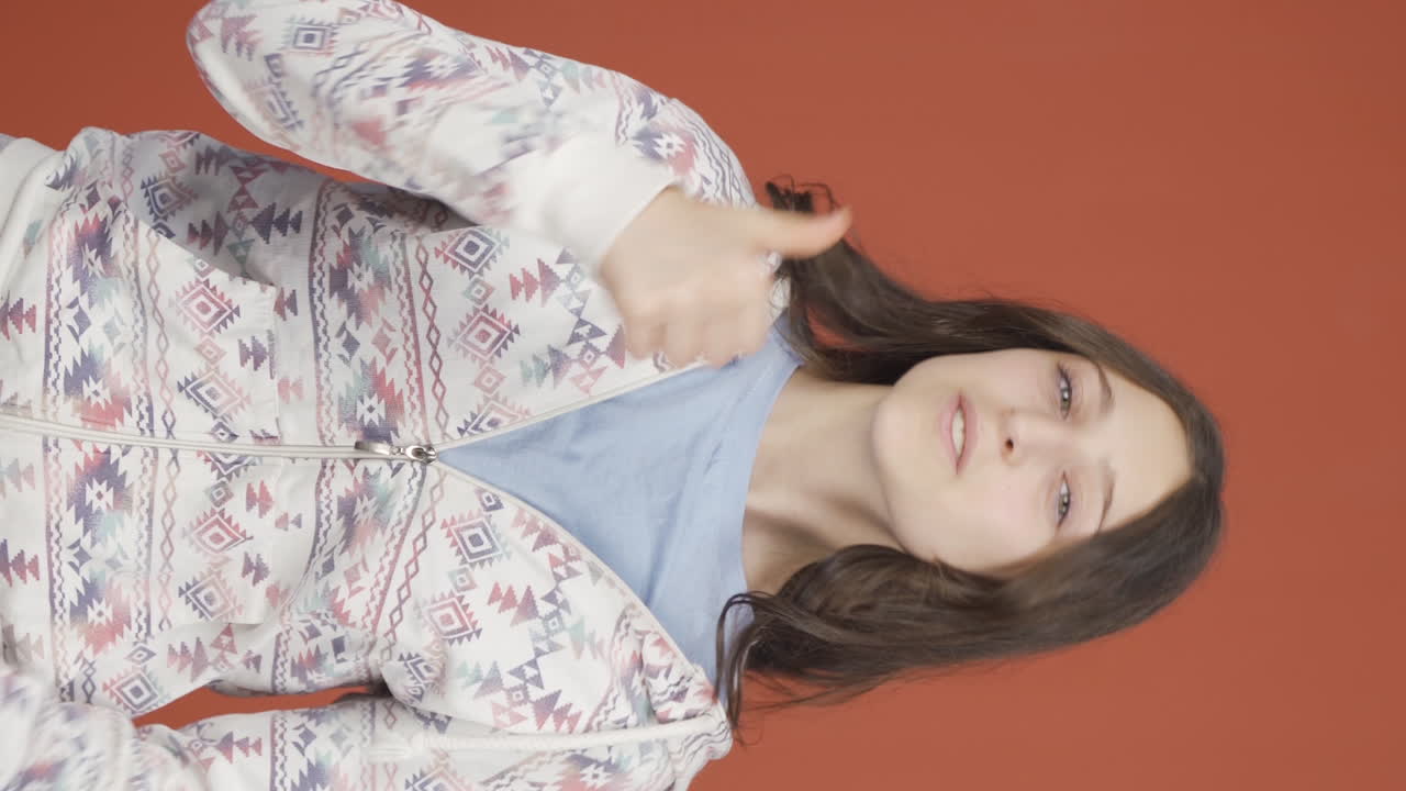 그녀가 들은 뉴스를 좋아하고 승인한 젊은 여성의 수직 비디오입니다.